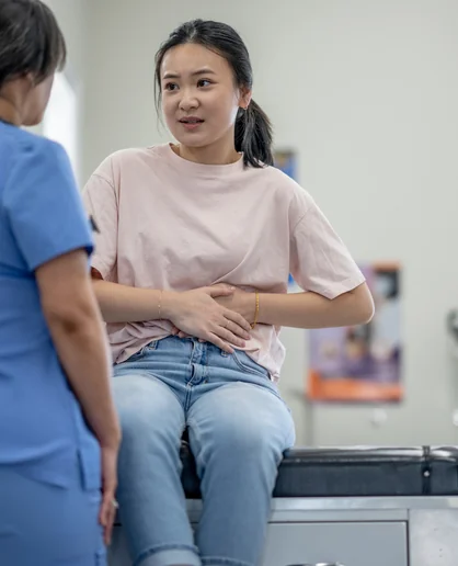 Pap smear preparation: a young woman talks with a nurse at Klinik Medilove Keponggi before her test